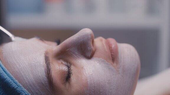 在美容院接受皮肤护理的女性保湿面膜脸部特写