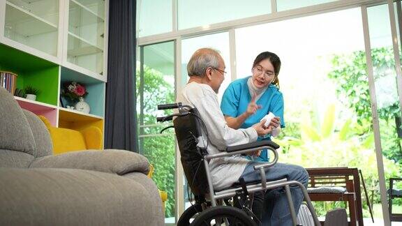 亚洲老年男性患者在敬老院与医生护士咨询处方药护工治疗师药剂师妇女在客厅里拿着药瓶药量在家里