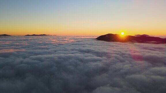 鸟瞰生机勃勃的日出在白色的云层与大山