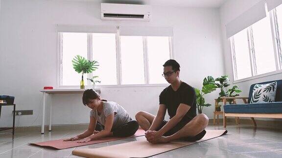 年轻的亚洲夫妇正在家里进行健身训练