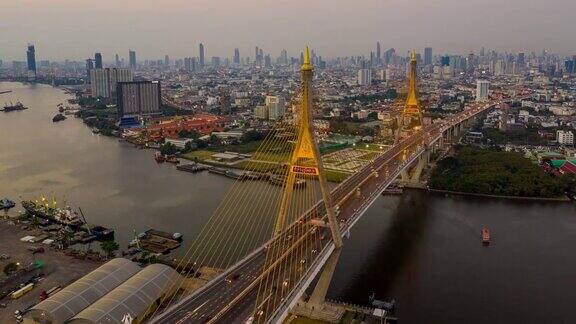 泰国曼谷普密蓬悬索桥横跨湄南河在夕阳下的天空和云彩中桥上有一辆汽车