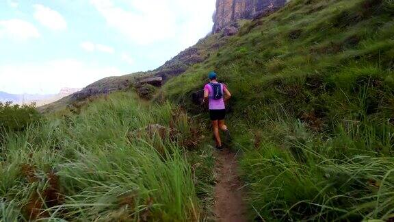 健康的女人在一条极端的山路上奔跑