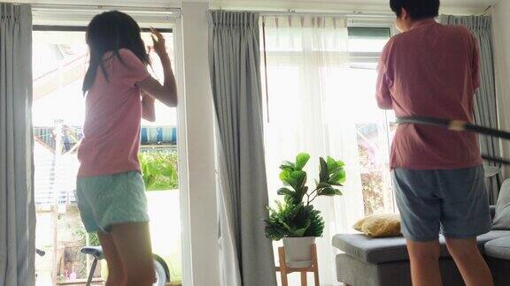 快乐的亚洲孩子在家里靠窗锻炼男孩在玩呼啦圈女孩在跳舞