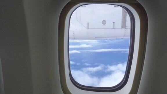 在飞机上透过窗座观看多云的蓝天