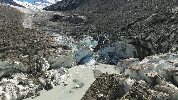 无人机俯瞰冰柱之间的寒冷池塘周围是粗糙的岩石山景观