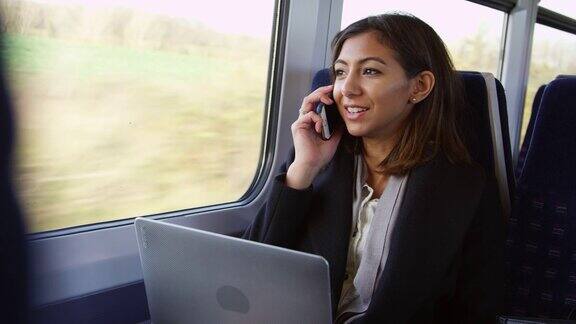 女商人在火车上使用笔记本电脑和电话拍摄的R3D