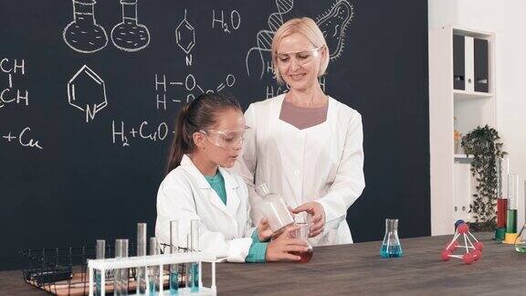 女学生和化学老师在教室里做实验