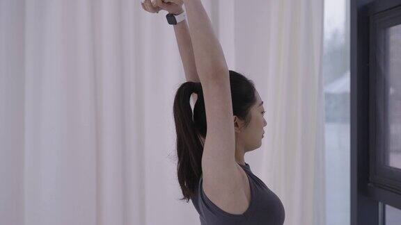 年轻的亚洲女性穿着瑜伽裤在瑜伽垫上练习瑜伽