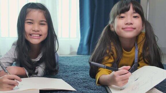 年轻的亚洲女儿兄弟姐妹孩子幸福躺在地板客厅网上学习的家庭背景