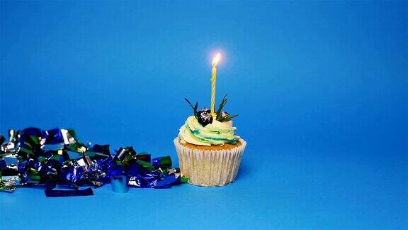 蓝色背景上插着三支燃烧的蜡烛的生日蛋糕
