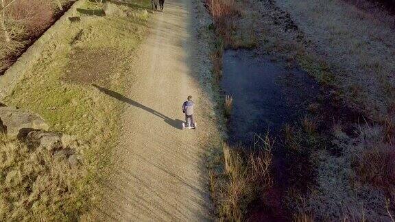 小男孩骑着悬浮滑板在乡间小路上驰骋
