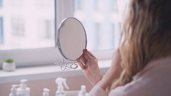 金发女子在美容室照镜子皮肤治疗程序