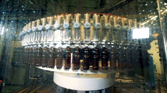 工厂的机器用啤酒填充瓶子近距离