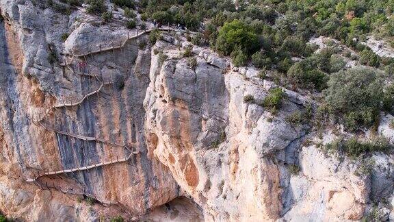 全景美丽的令人眩晕的令人印象深刻的鸟瞰图在岩石悬崖上的木制楼梯的顶部到底部这是西班牙比利牛斯山脉加泰罗尼亚的CongostdeMontrebei峡谷徒步旅行路径的一部分4k的视频