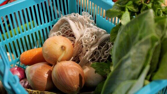 洋葱放在装满各种蔬菜的篮子里购物篮里有胡萝卜蔬菜放上几颗洋葱顶视图是素食主义者吃蔬菜和水果的产品购买蔬菜