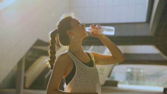 年轻女子在运动后喝水