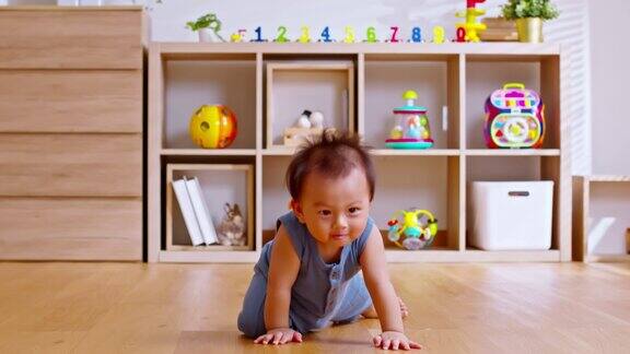 健康的亚洲婴儿蹒跚学步在地板上爬行学习在室内爬行可爱的宝宝保持她的肚子和腿在地板上爬行的乐趣和幸福在家里育婴室