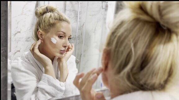 女人在浴室里照镜子照顾自己的皮肤