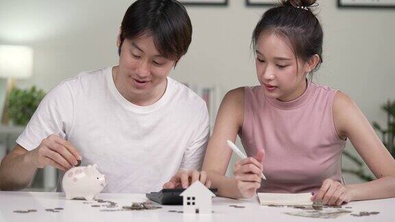 年轻的亚洲夫妇正在攒钱买房年轻的亚洲夫妇谈论和制定住房按揭计划和住房贷款