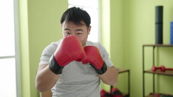 年轻的中国男子在体育中心拳击