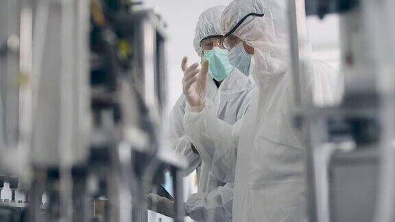 工程师工人在PPE套件质量控制自动化制造医疗口罩预防冠状病毒