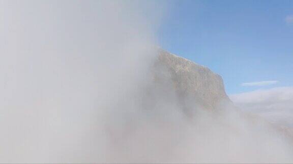 无人机飞行覆盖挪威JotunheimenBitihorn山在厚厚的云层