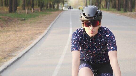 女自行车手在公园里骑自行车前跟随拍摄骑自行车慢动作