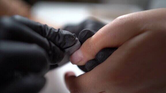 一名妇女在家里做美甲用指甲锉刀去除指甲上旧的凝胶指甲油选择聚焦特写