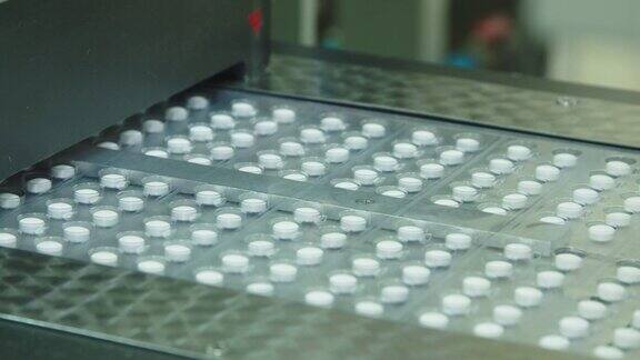 在传送带上用塑料包装的药片制药厂的自动吸塑包装药片包装机工艺特写用于药品生产的制药机械