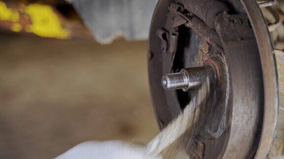 师傅用金属刷清洗安装在汽车车轮轴承上的轴