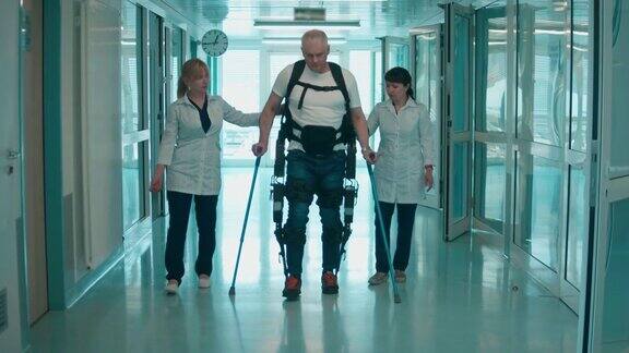 医生们正在帮助一名穿着防护服的残疾人行走