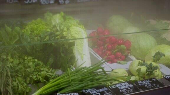 超市冰箱展柜里的新鲜绿色植物和蔬菜特写