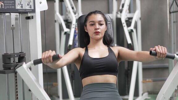 健康的亚洲女运动员在健身房锻炼身体举重