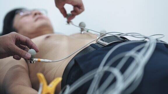 亚洲的中国医生在医院向护士解释给病人做心电图检查