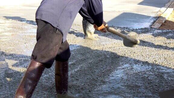 建筑工人在地面上浇水泥
