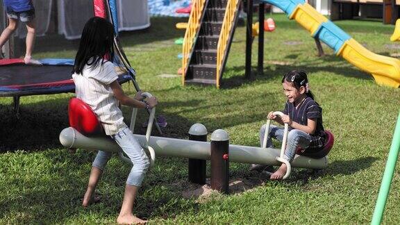 泰国孩子在操场上玩跷跷板