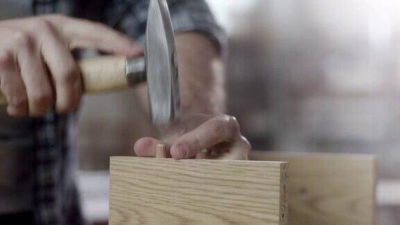 特写木匠用锤子组装家具