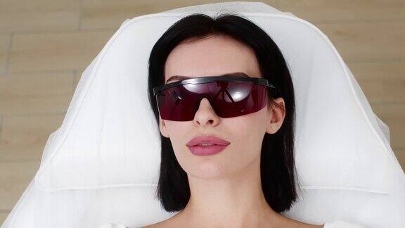 一名妇女正在使用激光进行整容手术美容诊所的面部护理改善皮肤状况的广告概念