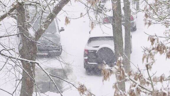 车在雪地里停在停车场暴雪冬日里飘落的雪花城市冬季背景