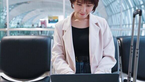 一位女士在机场使用笔记本电脑