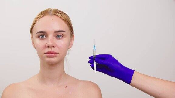 一个没有化妆的年轻女子她旁边是一个装有液体的注射器