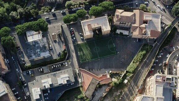 俯瞰美丽舒适的小镇和小房子足球场上男人在场上踢球