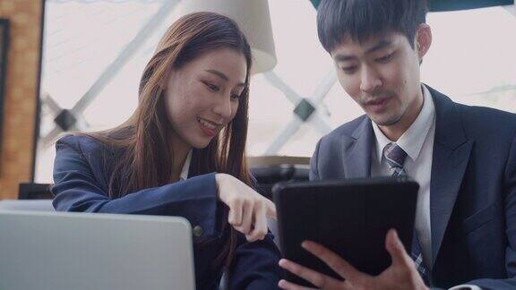 两个亚洲商人在用笔记本电脑聊天