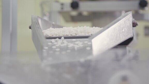 分拣好的药丸堆在自动包装设备中化工厂药品生产制药行业