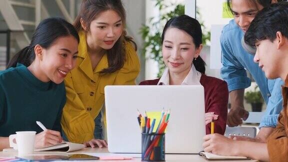 亚洲女性领导者建议uxui设计师在现代办公室的桌上进行手机应用界面线框图设计创意数字发展机构放松会议