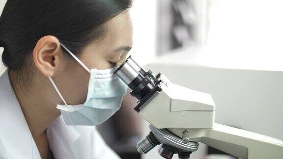在实验室里观察显微镜的科学家