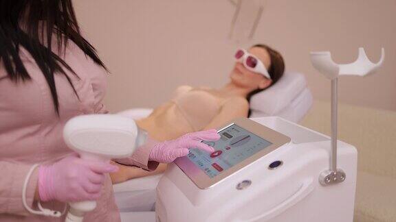 女美容师在美容院使用激光脱毛机美容院医师检查激光脱毛机