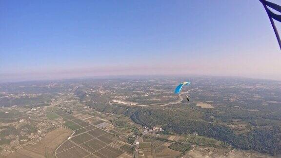 高空跳伞者在乡村上空飞行