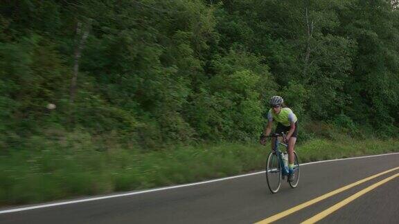 乡村公路上一个女自行车手的跟踪镜头