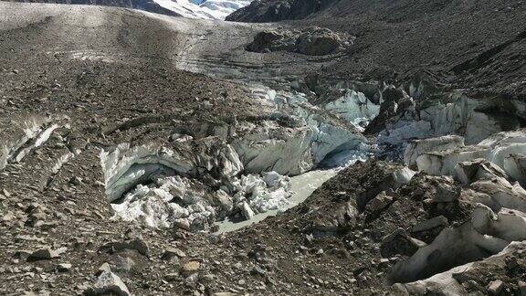 无人机俯瞰冰柱之间的寒冷池塘周围是粗糙的岩石山景观